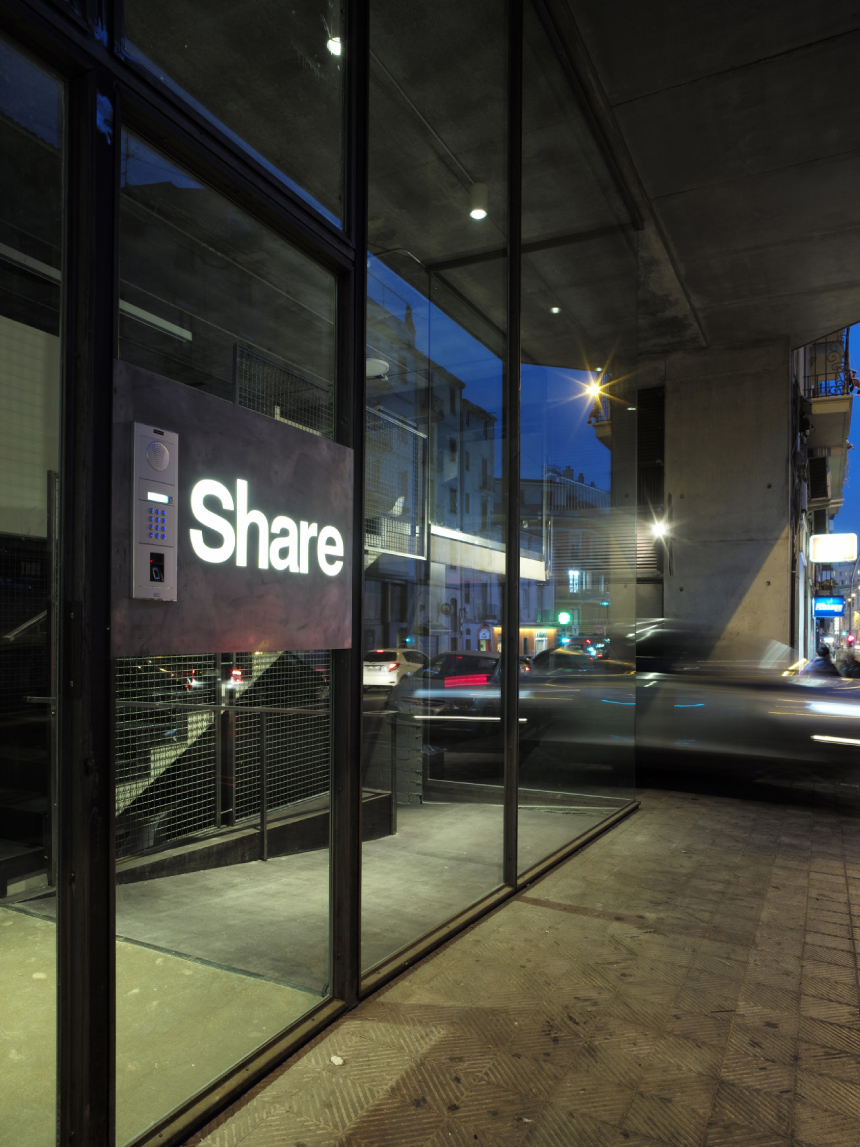 Acceso de Share con el rótulo iluminado de noche